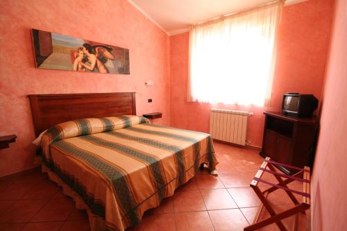 a bedroom with a bed and a television and a window at Case Vacanza Fiocchi in Arrone