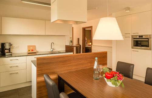 a kitchen with a wooden table with flowers on it at Hidalgo Suites in Postal