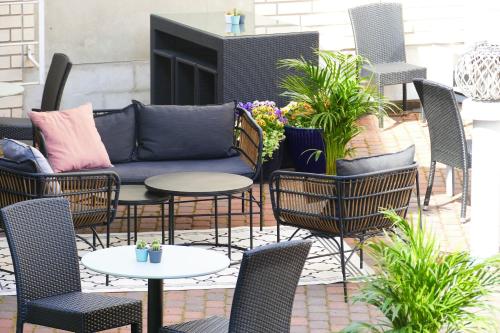 a patio with chairs and tables and a couch at Hotel Kalliohovi in Rauma