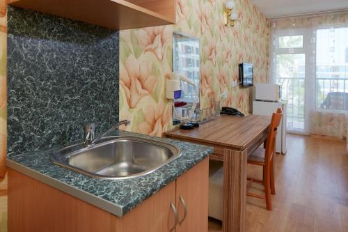 a kitchen with a sink and a wooden table at Hotel Yantra in Sunny Beach