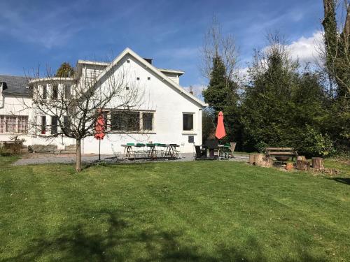 a white house with a picnic table in a yard at Gite La Cigogne in Couvin
