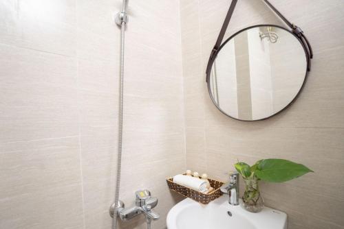 a bathroom with a shower and a sink and a mirror at Amor Fati home & Travel in Hanoi