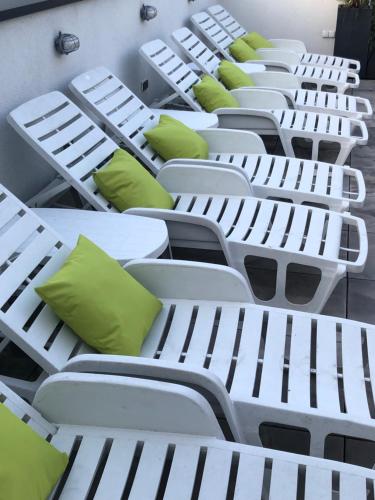 a row of white beds with green pillows on them at Hotel Imperium in Chełmża