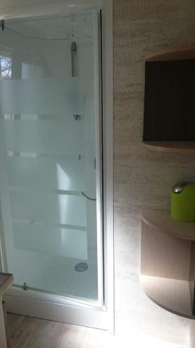 - une porte en verre dans une chambre avec une télévision dans l'établissement Mobil home récent clim 3ch Camping3* piscine, à Argelès-sur-Mer