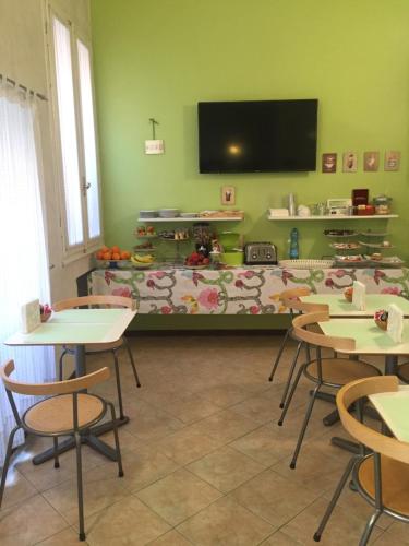 a classroom with tables and chairs and a flat screen tv at Castelfranco Hotel in Castelfranco Emilia