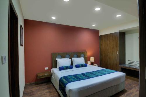 a bedroom with a large bed with a red wall at GeeKay Millenniaa in Vellore