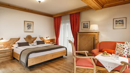 ein Schlafzimmer mit einem Bett, einem Tisch und einem Stuhl in der Unterkunft Der Verdinser Hof in Schenna