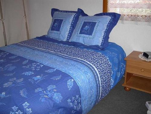 Una cama azul con sábanas y almohadas azules. en Mazet de vacances dans le Domaine de l'Espaï, en Saint-Martin-de-Brômes