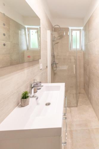 a bathroom with a white sink and a shower at Luxury rooms with balcony in Zadar