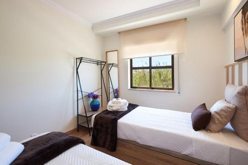 a bedroom with two beds and a window at Ericeira Sunset Lifestyle II in Ericeira
