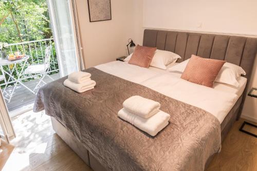 a bedroom with a large bed with white towels on it at Luxury rooms with balcony in Zadar