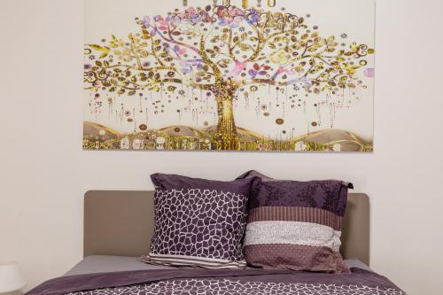 un quadro di un albero sopra un letto di Residenza del Duca - Casteldaccia 2 camere a Casteldaccia