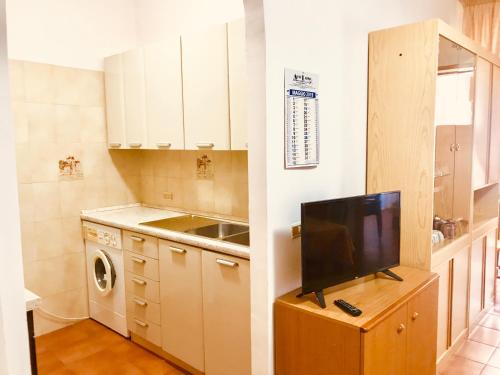 una cocina con TV en un armario de madera en Appartamenti Oleandri, en Vieste