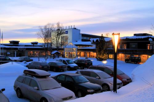 a parking lot with cars parked in the snow at Radisson Blu Resort, Beitostølen in Beitostøl