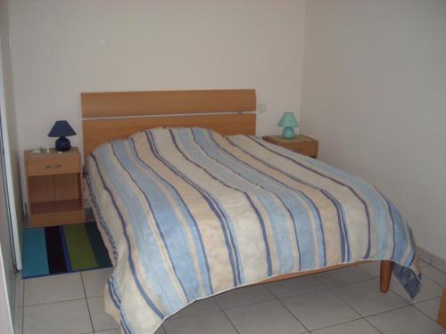 - une chambre avec un lit doté d'un couvre-lit rayé dans l'établissement Location à la semaine Paradis de Saint Cast, à Saint-Cast-le-Guildo