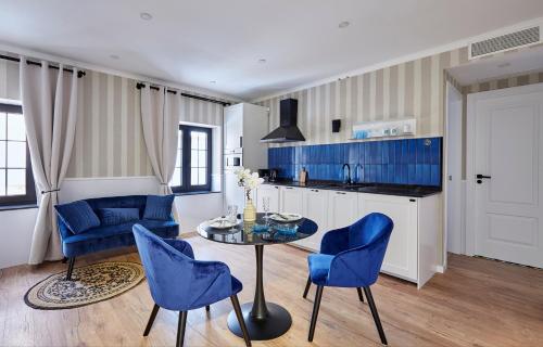 a kitchen with blue chairs and a table at "Breeze" Aparthotel by Parrot`s House in Lloret de Mar
