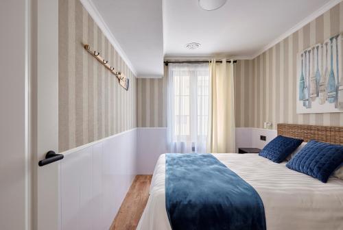una camera da letto con un grande letto con cuscini blu di "Breeze" Aparthotel by Parrot`s House a Lloret de Mar