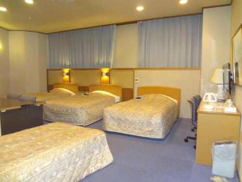 a hotel room with three beds in a room at Asano Hotel in Kitakyushu
