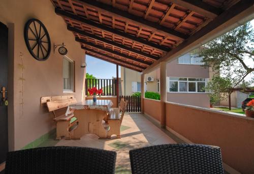 patio con mesa y sillas en el balcón en Apartment and Holiday Home Mladenka, en Pula