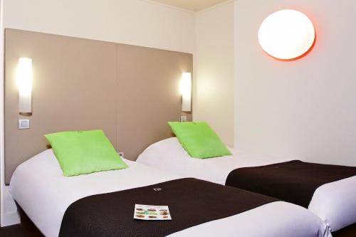 a hotel room with two beds with green pillows at Campanile Le Havre Nord - Montivilliers in Montivilliers