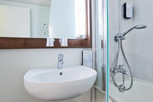 a bathroom with a sink and a shower at Campanile Le Havre Nord - Montivilliers in Montivilliers