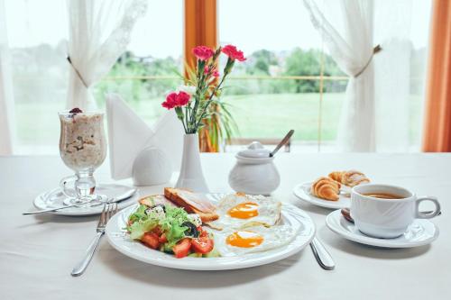 una mesa con un plato de desayuno y una taza de café en Hotel Patriarshyi en Leópolis