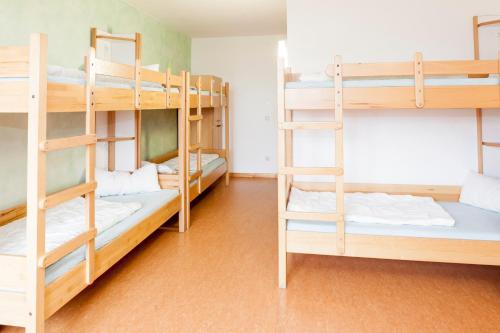 a room with three bunk beds in a hostel at Jugendherberge Berchtesgaden in Berchtesgaden