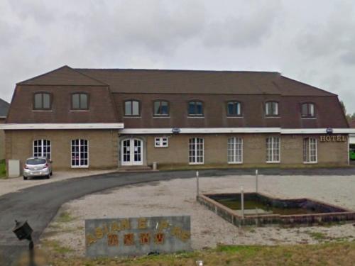 a large brick building with a sign in front of it at Hotel Asian Empire in Kuurne