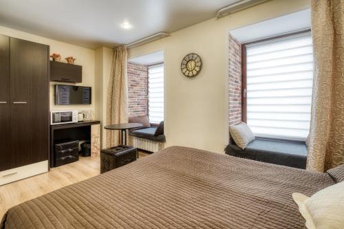 a bedroom with a bed and a couch and a window at Egyptian House in Saint Petersburg