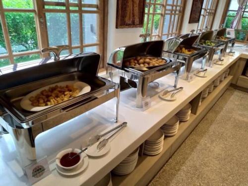 una línea de buffet con varias bandejas de comida en Hualien Tourism Sugar Factory Hotel, en Guangfu