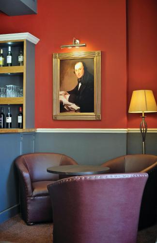 a painting of a man in a suit on a wall at Royal Hotel in Bath