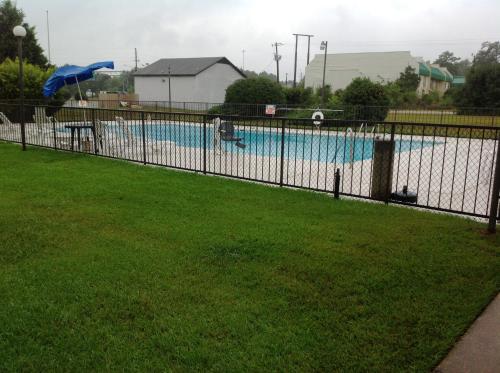a fence in front of a swimming pool at Days Inn by Wyndham Fayetteville-South/I-95 Exit 49 in Fayetteville