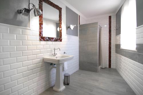 a white bathroom with a sink and a mirror at Casa Rural Palacete Magaña in Malón