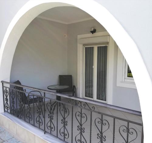 a balcony with a black railing and a desk at Delphin Rooms Sivota in Sivota