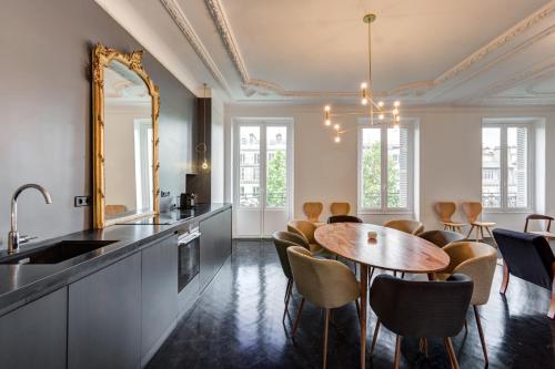 - une cuisine avec une table, des chaises et un miroir dans l'établissement Habitat Parisien - Drouot Luxe, à Paris