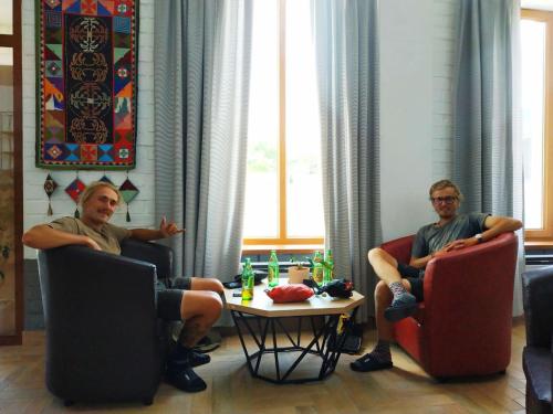 two men sitting in chairs in a room at ololoFreelander Hostel&Coworking in Bishkek