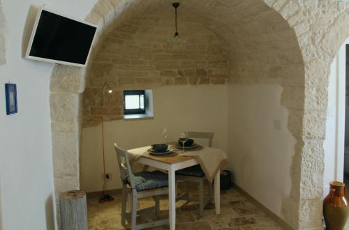 a dining room with a table and a tv at Il Trullo di Mari' - Locazione turistica in Alberobello