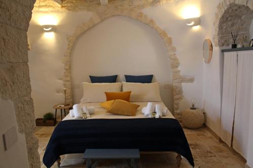 a bedroom with a large bed with a stone wall at Il Trullo di Mari' - Locazione turistica in Alberobello