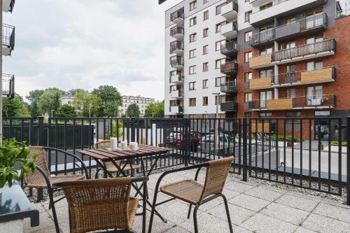 a patio with tables and chairs and a fence at Apartments Claro II by Renters in Krakow