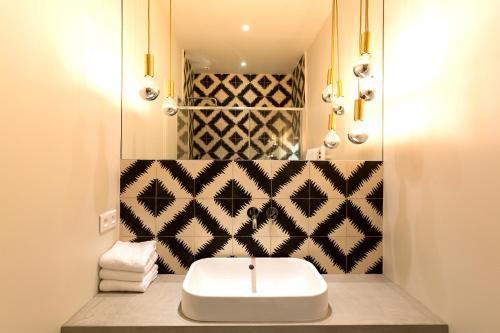 une salle de bain avec un lavabo blanc et un miroir dans l'établissement Habitat Parisien - Drouot Luxe, à Paris