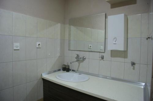 a bathroom with a sink and a mirror at Guest House Via in Bitola