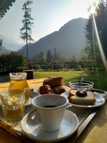 a tray of food with a cup of coffee and pastries at Agriturismo Pian dei Tass in Barcis