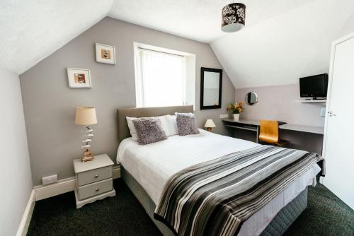 Un dormitorio con una cama grande y una ventana en Surfside Stop, en Newquay