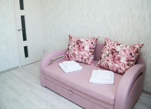 a pink couch with two pillows in a living room at New House Comfort Apartment in Odesa