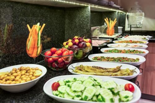 een buffet met borden met eten en kommen met groenten bij Kupeli Hotel in Istanbul