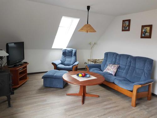 a living room with a blue couch and a table at Ferienwohnung Klütz - Unterkunft mit 2 Schlafzimmern und modernem Bad in Oeversee
