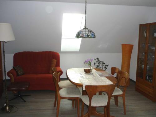 a living room with a table and a red chair at Ferienwohnung Klütz - Unterkunft mit 2 Schlafzimmern und modernem Bad in Oeversee