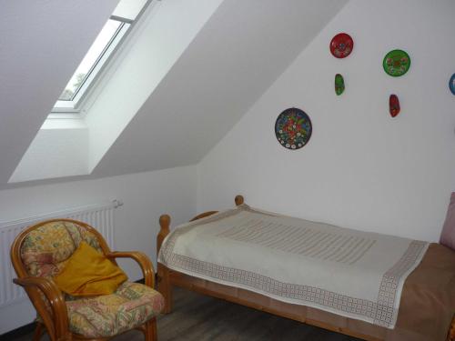 - une chambre avec un lit, une chaise et des assiettes murales dans l'établissement Ferienwohnung Klütz, à Oeversee