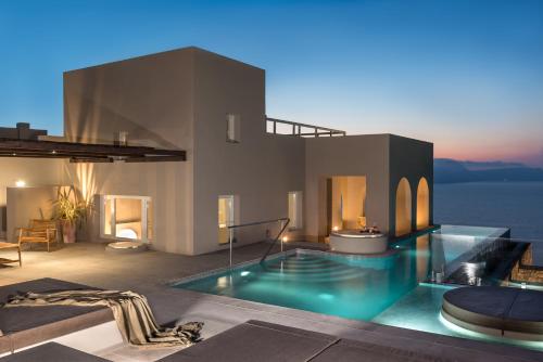 uma villa com piscina à noite em Arota Exclusive Villas em Acrotíri
