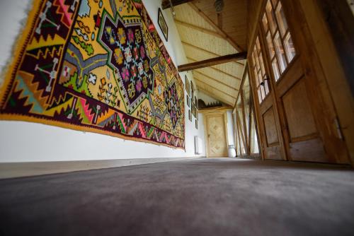 a room with a tapestry hanging on the wall at Satul Banului Guesthouse in Măgureni